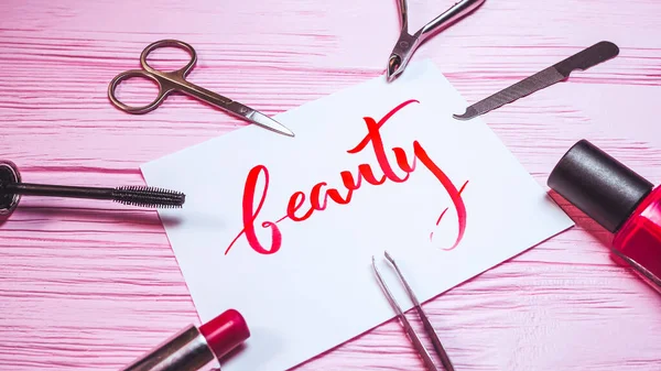 Beauty text. Font of lettering word on white paper with red ink by calligrapher. Cosmetic products frame. Graphic design, handwriting, lettering, concept. High quality photo