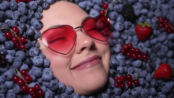여자는 열매들 빌베리 곱슬곱슬 열매들 목격하게 블루베리로 뒤덮인 유기농 식물을 — 비디오