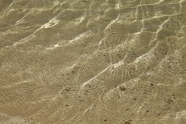 Ein Hintergrund aus Sonne und Schatten auf sandigem Meeresboden — Stockfoto
