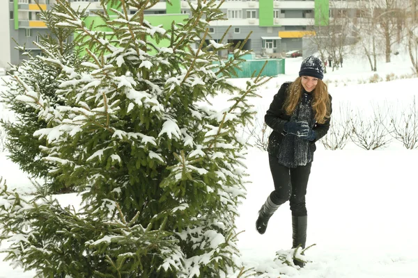 Menina de inverno atrás da árvore de neve — Fotografia de Stock