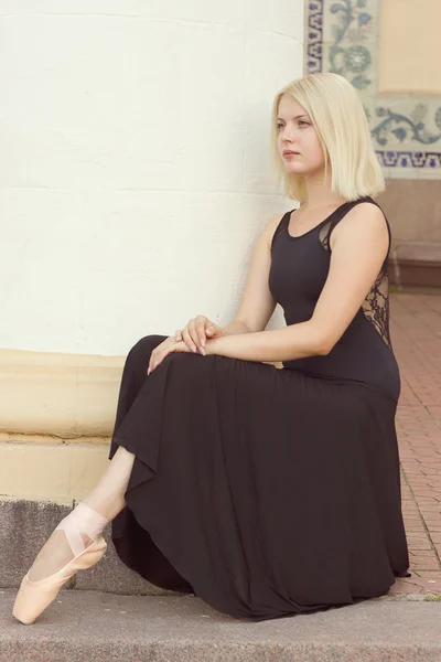 Dançarino em um vestido preto e sentado — Fotografia de Stock