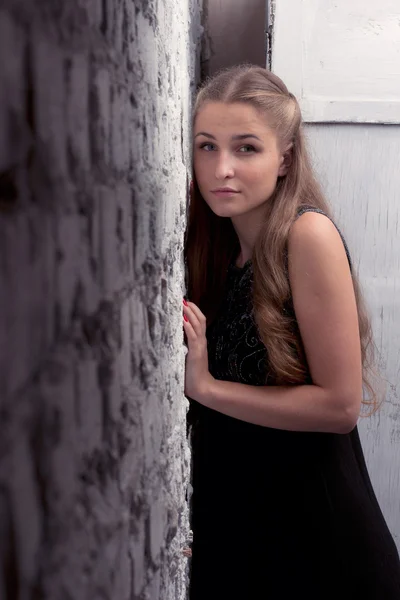 Girl leaning body to a brick wall — Stock Photo, Image