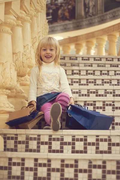 Girl 3 years old sitting with shopping — Stock Photo, Image