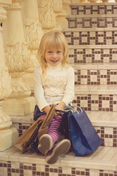 Happy blond girl 3 years old with shopping — стоковое фото