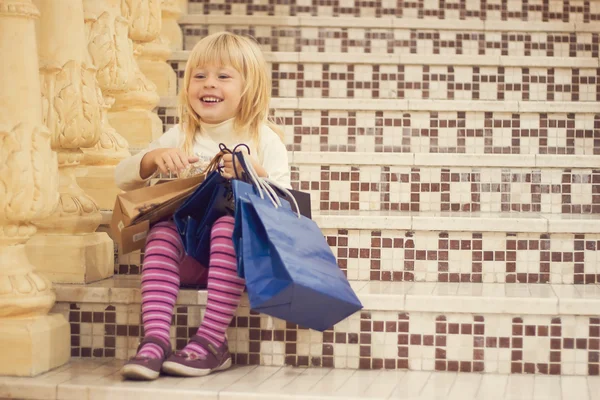 Pleased blonde girl 3 years old with shopping — Stock Photo, Image