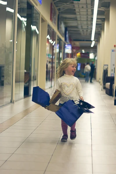 Blond flicka 3 år kör med shopping — Stockfoto