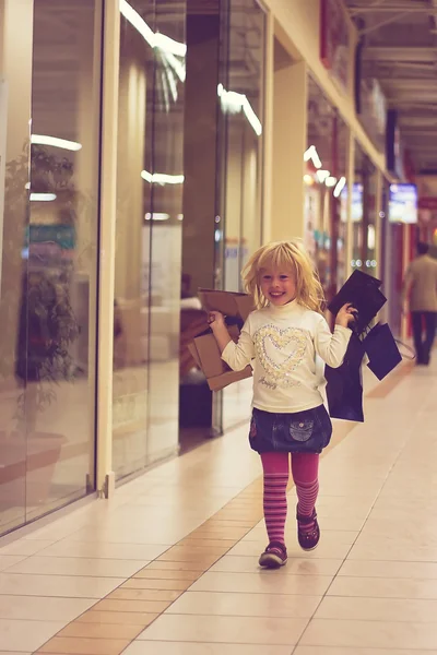 Blonde girl 3 years old running with shopping — Stock Photo, Image