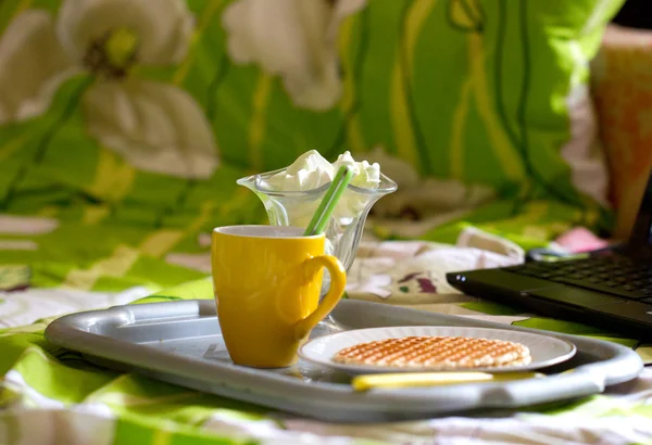 Runde Waffeln und Tee in der Nähe von Laptop — Stockfoto