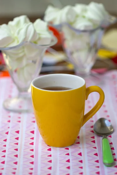 Té en taza amarilla con dulces — Foto de Stock