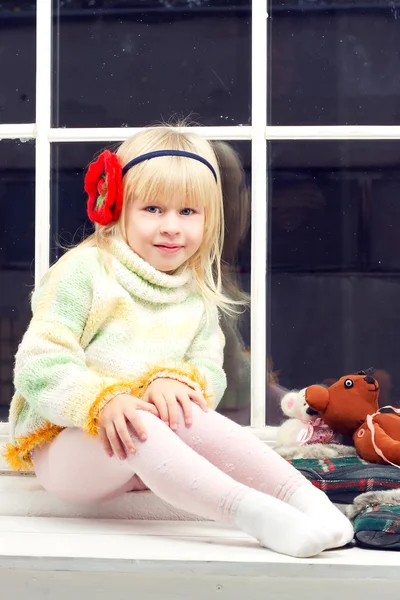 Little girl in a knit sweater and looks the camera — Stock fotografie