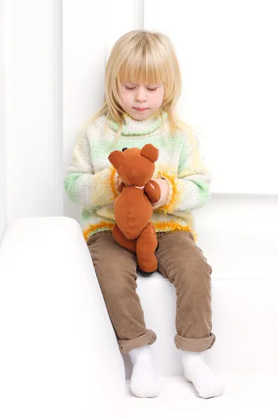 Little girl 3 years old sitting on a white couch — Stock Photo, Image