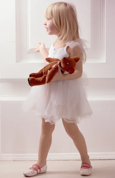 Chica en un vestido blanco con juguete — Foto de Stock