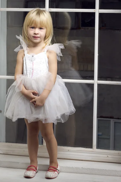 Girl 3 years old in a white dress near window — Stock Photo, Image