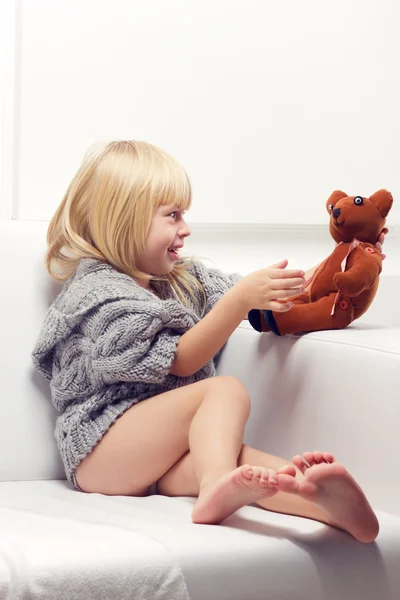 Petite fille avec ours sur canapé — Photo