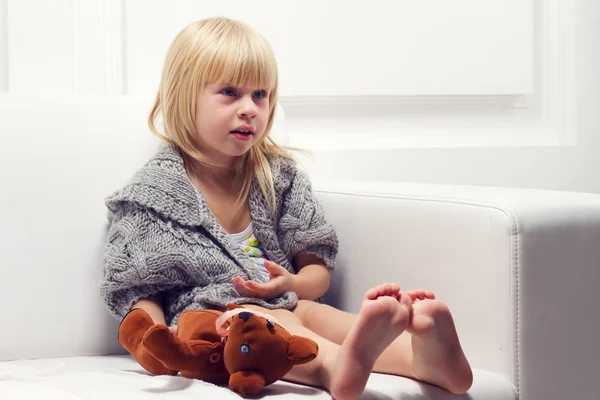 Kleines Mädchen mit Bär auf dem Sofa — Stockfoto