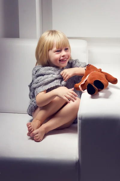 Bambina con orso sul divano — Foto Stock