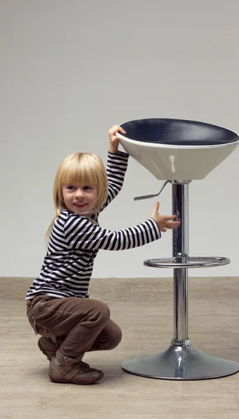 Blonde girl 3 years sat near a high chair — Stock Photo, Image