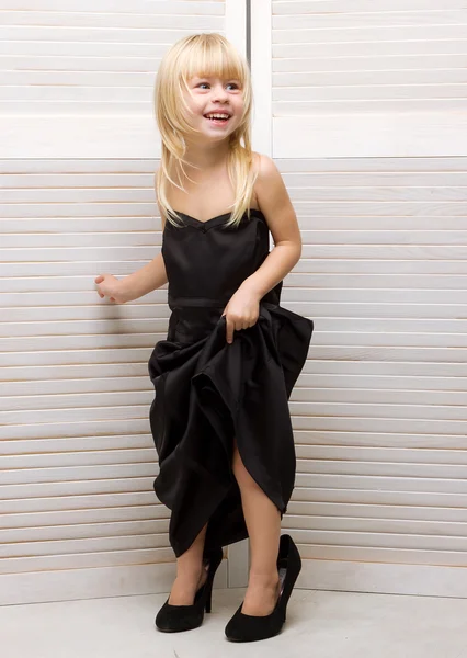 Flicka 3 år gammal i mammas klänning och högklackat — Stockfoto