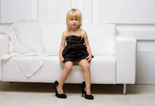 Little girl trying on the big shoes — Stock Photo, Image