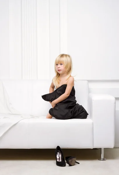 Girl lying on a white sofa in my mother's dress, — Stock Photo, Image