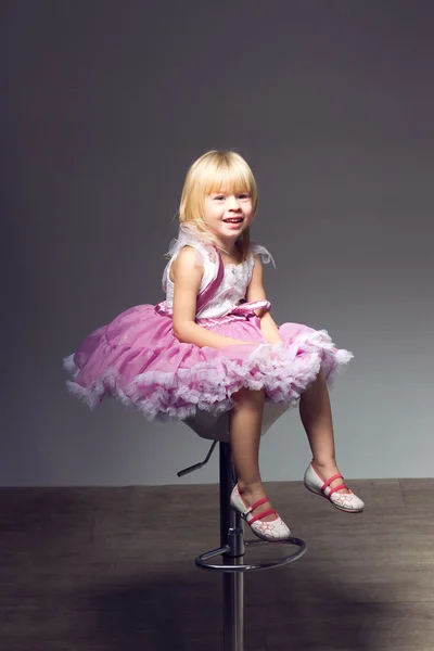 Girl in pink tutu, studio sitting a chair — Stock Photo, Image