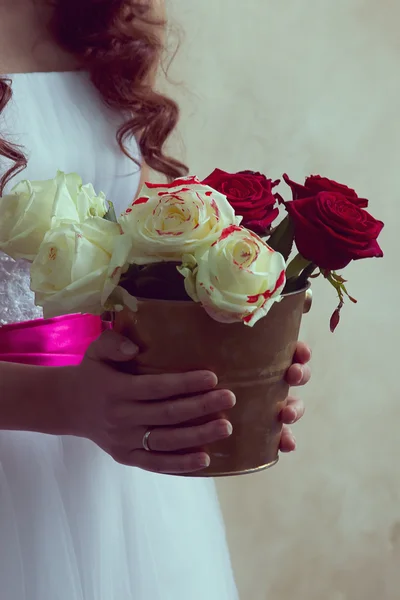 Girl holding a bucket of roses — Stock Photo, Image