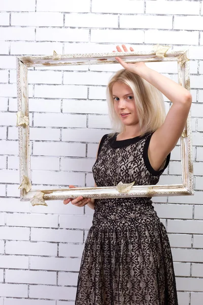 Mooie blonde in witte jurk met een frame — Stockfoto