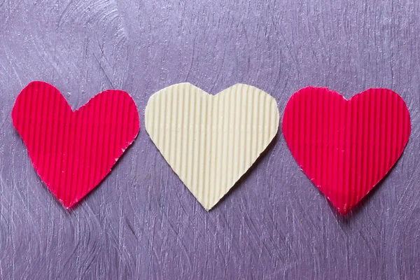 Three paper hearts on the purple board — Stock Photo, Image