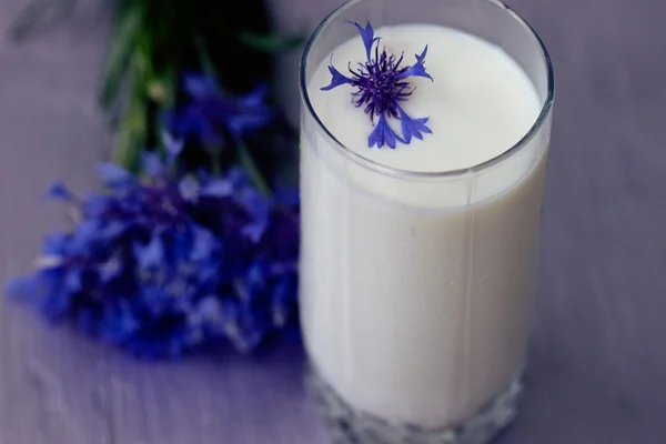 Vidro de leite e um buquê de flores de milho — Fotografia de Stock