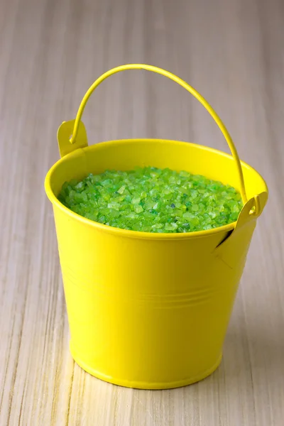 Geel emmer met een groene zeezout — Stockfoto