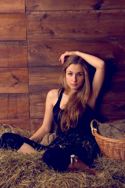 Beautiful smiling woman on haystack at farm — Stock Photo, Image