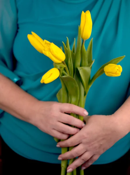 Vieja sosteniendo tulipanes amarillos —  Fotos de Stock