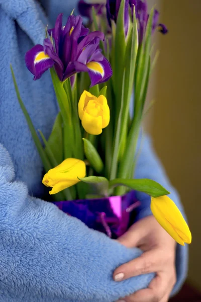 Woman hugging a bouquet of tulips and irises — Stock Photo, Image
