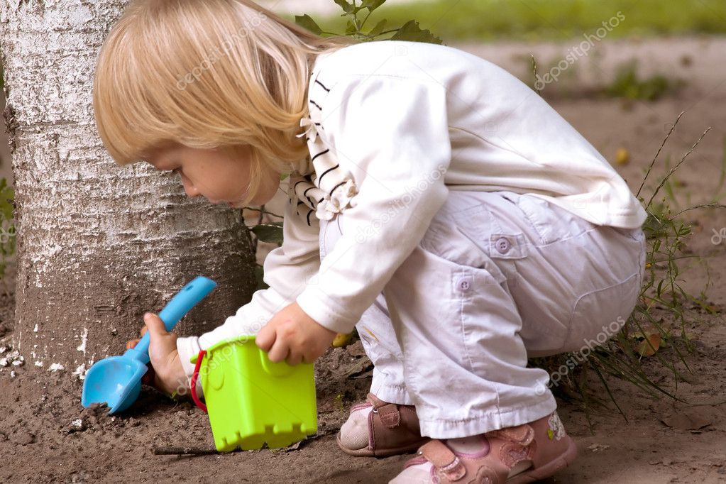 Little girl digging a plastic shovel