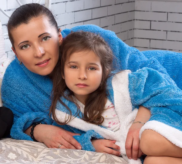 Mom and daughter in blue terry robes — Stock Photo, Image