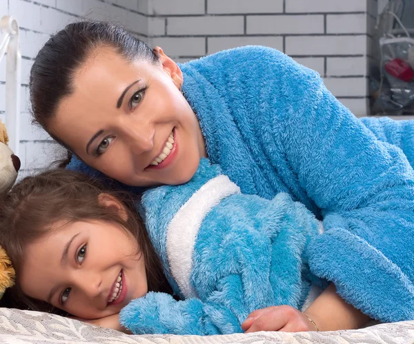 Female and girl in the same blue terry robes — Stock Photo, Image