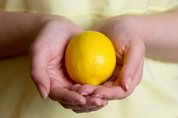 Girl in a yellow dress holding lemon — Stock Photo, Image