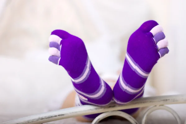 Female feet in bright purple socks