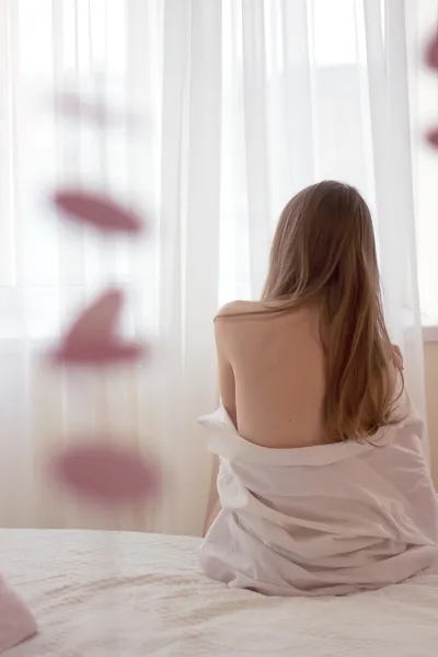 Indietro della ragazza sul letto — Foto Stock