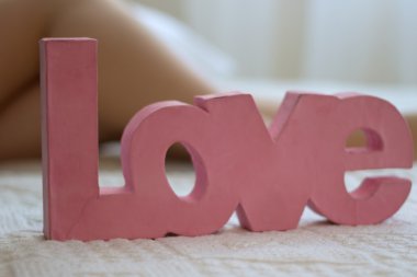 kelime aşk kadın ayakları yakınındaki bir yatakta