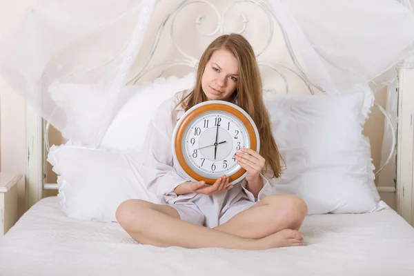 Young beautiful woman in bed and alarm clock Stock Image