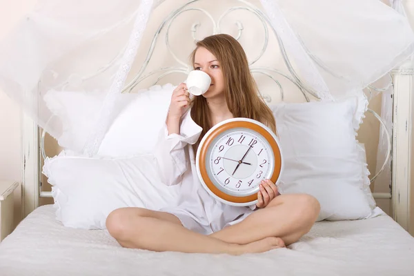 Young beautiful woman in bed and alarm clock Stock Photo