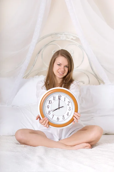 Young woman in bed and alarm clock Stock Photo