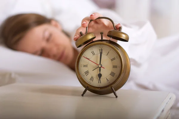 Chica está durmiendo y apaga la alarma —  Fotos de Stock