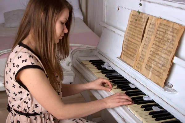 Ung kvinna spela piano — Stockfoto