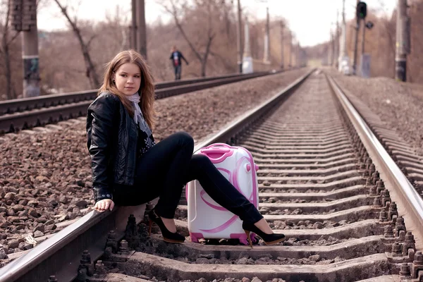Chica sentada en una maleta — Foto de Stock