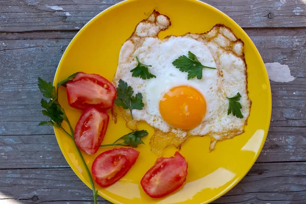 Ovos mexidos com tomate em uma placa amarela — Fotografia de Stock