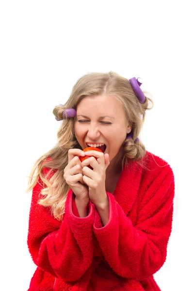 Girl in red robe eating a tomato — Stock Photo, Image