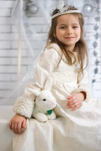 Menina no vestido de férias de inverno com coelho de brinquedo — Fotografia de Stock