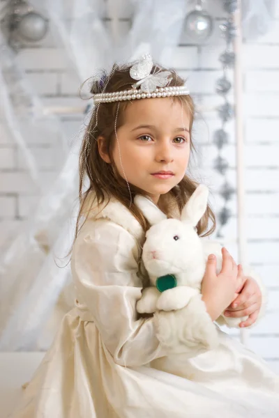 Mädchen im Winterurlaub Kleid mit Spielzeugkaninchen — Stockfoto